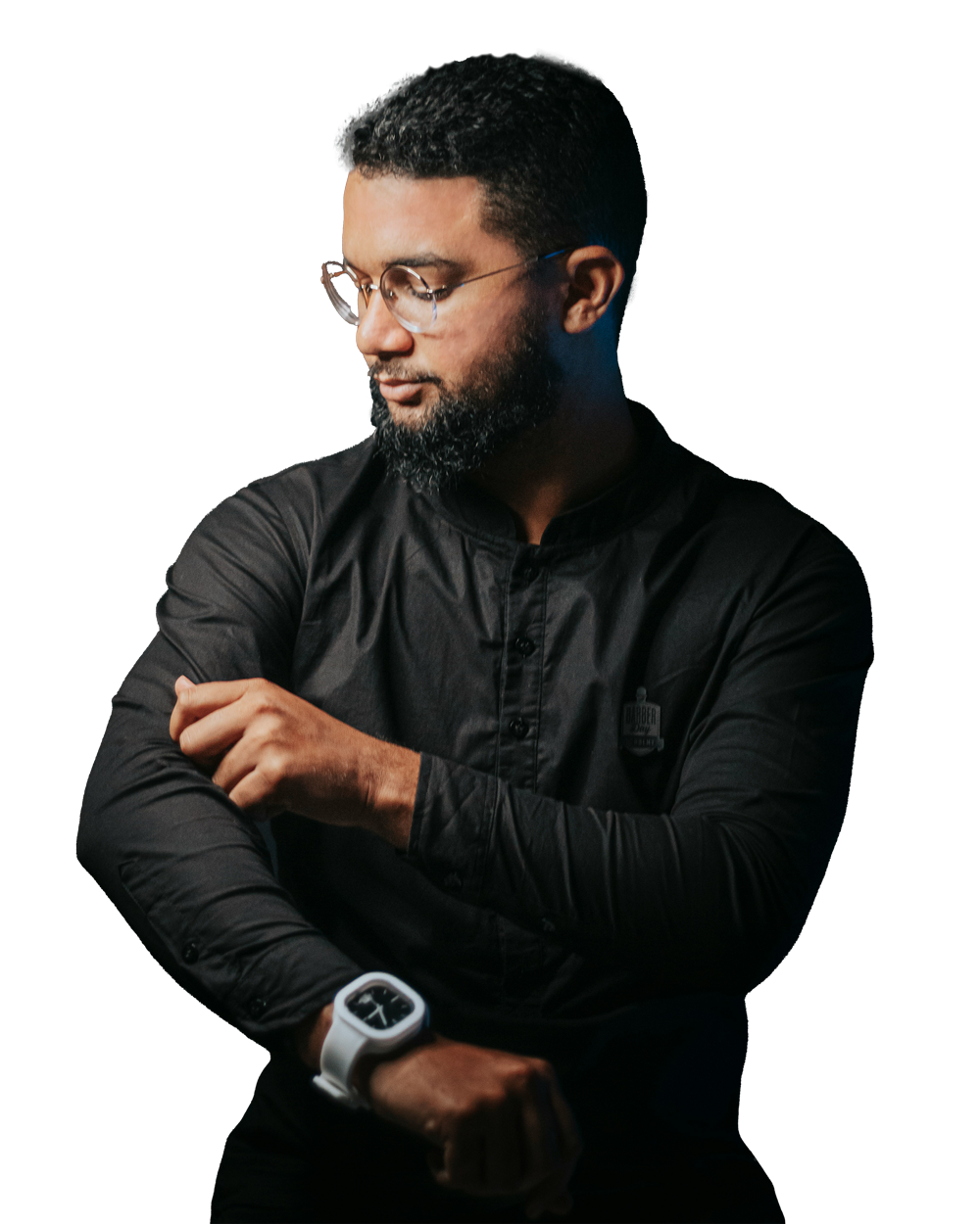 Hombre con gafas ajustándose la manga de una camisa negra.